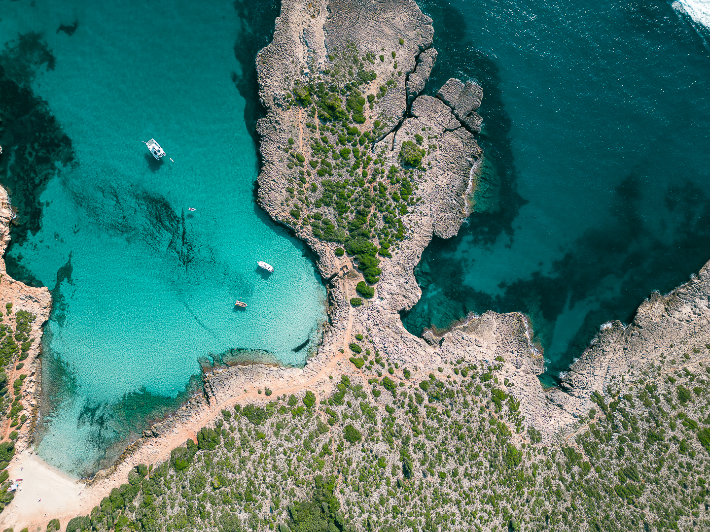 Aerial view of Cala Varques turquoise water and limestone cliffs
